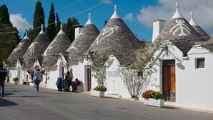 Uma fileira de edifícios tradicionais com telhados cônicos, paredes brancas e céu limpo.
