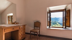 A room with a wooden desk, a chair, a large mirror, and a window with an open shutter. - Casa Gabriello (Pescaglia)