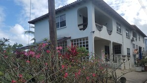 Un edificio de dos pisos con amplios ventanales y un balcón.