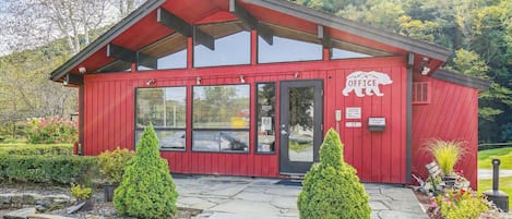 Un edificio de oficinas rojo con techo inclinado, ventanas grandes y un cartel que dice 'OFFICE'.