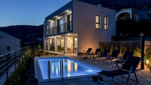 A modern two-story house with a swimming pool, outdoor seating, and a mountain backdrop. - Modern house with private pool, family-friendly, WiFi, barbecue, sea view, quiet (Makarska)