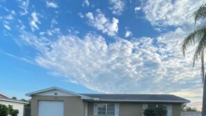 Una casa con garaje, un césped cuidado y un cielo despejado.