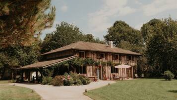 Guests can enjoy a tranquil atmosphere in this traditional building, surrounded by a lush lawn and trees.