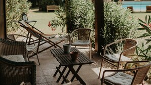 Un patio al aire libre con mobiliario de mimbre, una mesa y sillas.