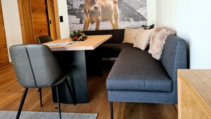 Un soggiorno moderno con un divano grigio, un tavolo da pranzo in legno e una sedia nera.