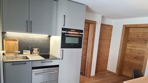 Una cucina moderna con mobili grigi, forno integrato e microonde.
