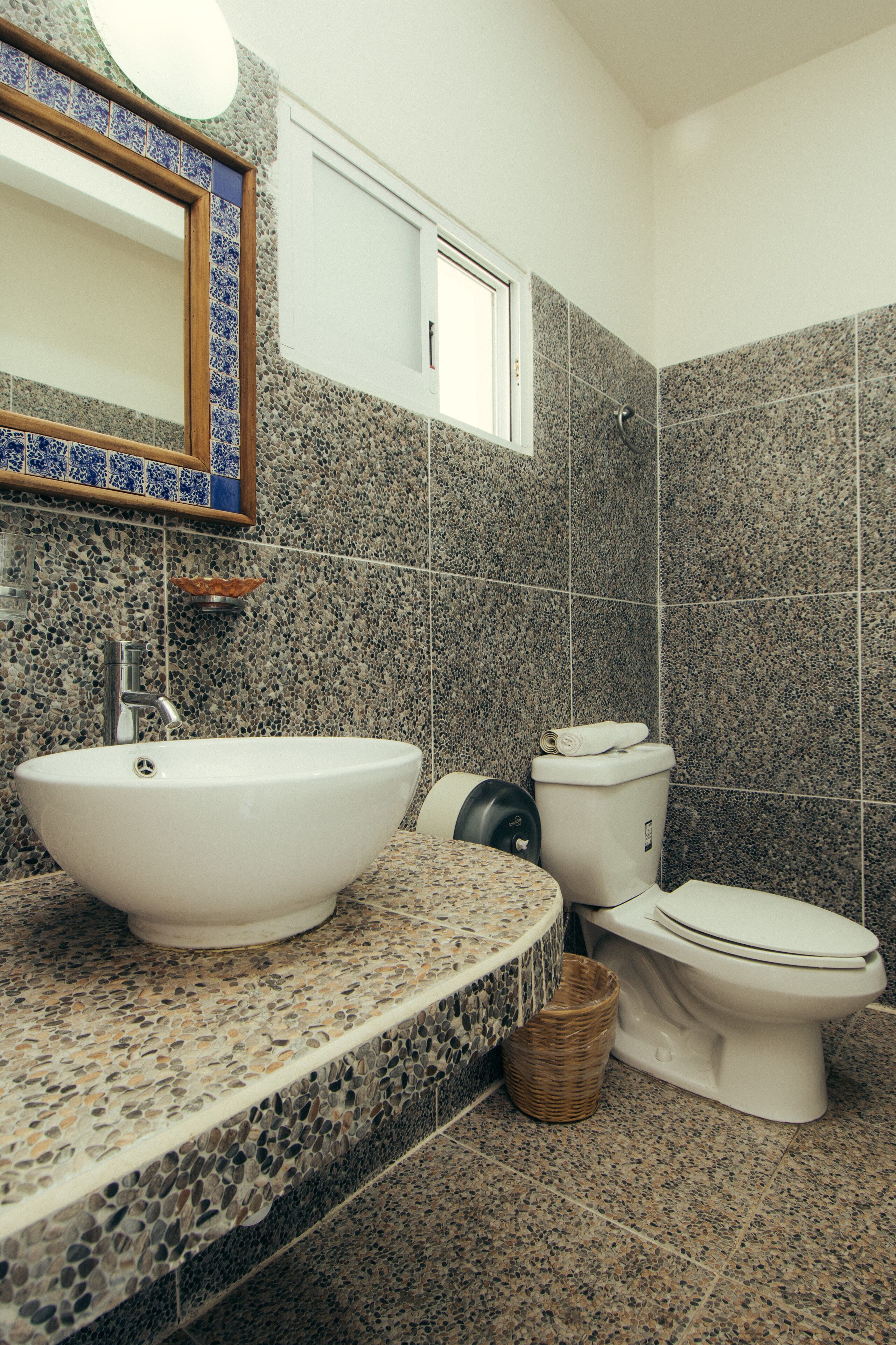 Un baño con un lavamanos blanco, un inodoro y un espejo.