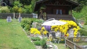 A wooden cabin with a garden in front, surrounded by a wooden fence. - Wetterstein with mountain panorama view (Untergrainau)