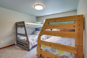 Un dormitorio con dos literas, una lámpara de techo y suelo cubierto de alfombra.