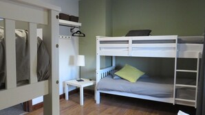 Dormitorio con literas, una mesita y una lámpara.