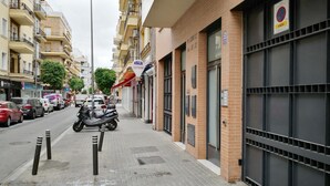 A street with parked motorcycles, cars, and a building with a sign for 'HIDALBE ELECTRICIDAD'. - Quiet and elegance in the Andalusian capital 4 px-WIFI (Sevilla)
