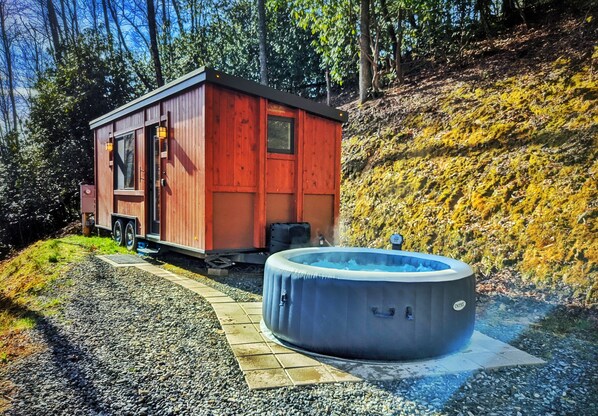 Relax in this cozy cabin, featuring a hot tub and a door with a window for natural views.