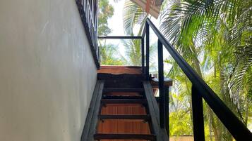 A wooden staircase with black railings leading to a wooden door.