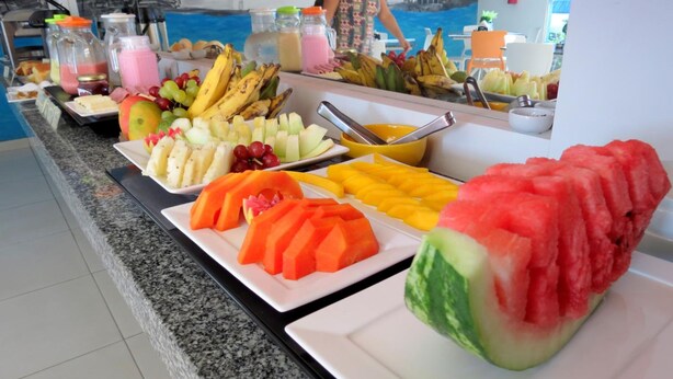 A buffet with various fruits and beverages. - Hotel Encantos De Penedo (Penedo)