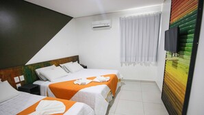 A hotel room with two beds, a TV, and an air conditioning unit. - Hotel Encantos De Penedo (Penedo)