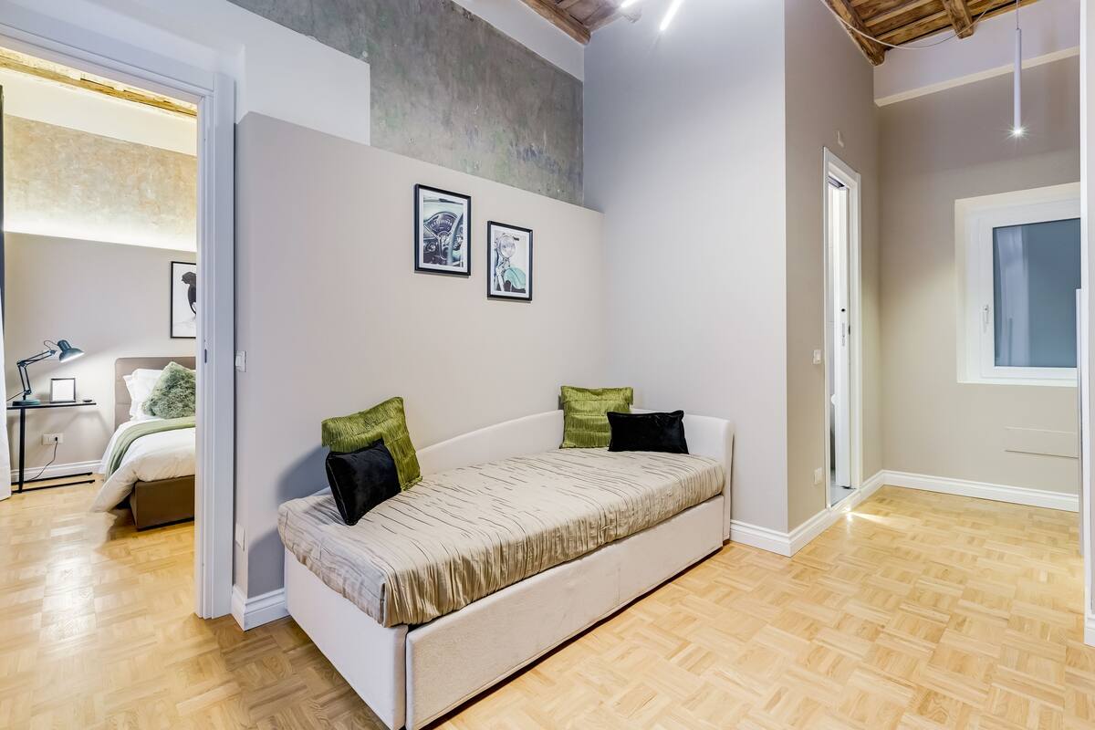 Una sala moderna con un sofá, dos cuadros enmarcados y suelo de madera.