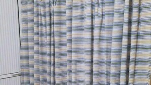 A bathroom with a striped shower curtain, a white door, and a tiled floor. - Amplias y Confortables Habitaciones (San Juan Bautista Tuxtepec)