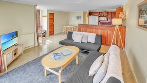 Relax in this inviting living space with a flat-screen TV, comfortable sofa, and dining area.