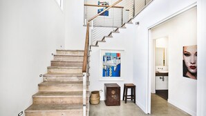 A staircase with wooden steps, a metal handrail, and a wall-mounted picture. - Oceanside - Pet Friendly Absolute Beachfront (Culburra Beach)