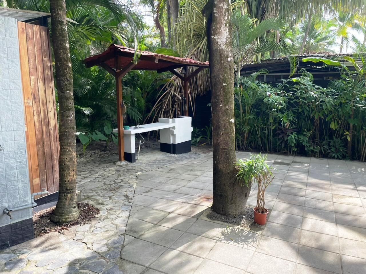 Un patio con piso de piedra, un banco de madera y una planta pequeña en maceta.
