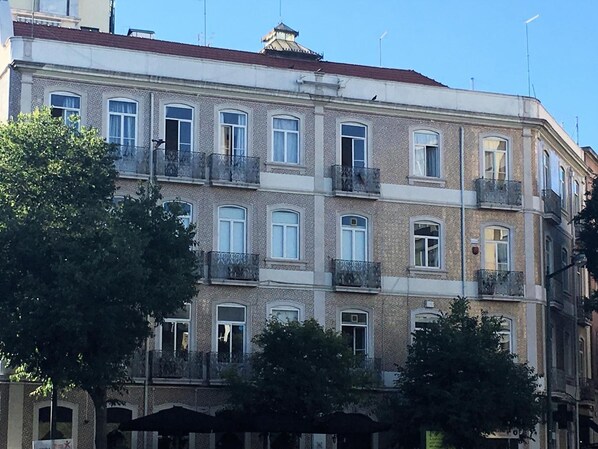 A multi-story building with balconies, large windows, and a traditional architectural style.