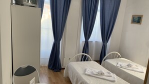 Een kamer met twee bedden, een klein tafeltje en een televisie.