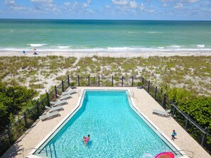 Enjoy a serene beachfront setting with ocean views, a pool, lounge chairs, and a children's pool.