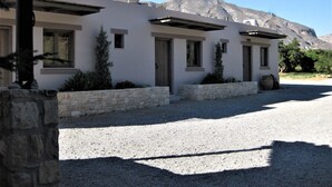 Una casa moderna de dos pisos amb fonamentació de pedra, nombroses finestres i un camí d'accés de grava.