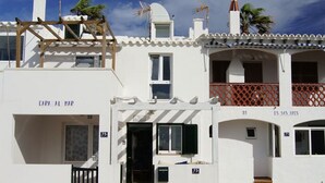 A white building with balconies, a wooden pergola, and a sign reading "Capa al Mar". - Enchanting fisherman’s cottage in front of the sea in Biniancolla (Biniancolla)