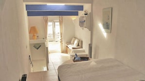 A hotel room with a bed, a desk, a chair, a lamp, and a view of the outdoors. - Enchanting fisherman’s cottage in front of the sea in Biniancolla (Biniancolla)