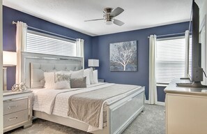 Relax in a stylish bedroom with a large bed, nightstands, and a ceiling fan.
