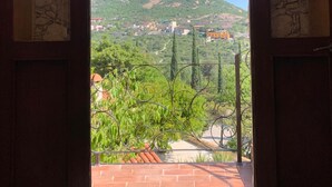 An open doorway with a view of a mountain and a town. - Hotel Zidada and Chalets (Ezequiel Montes)