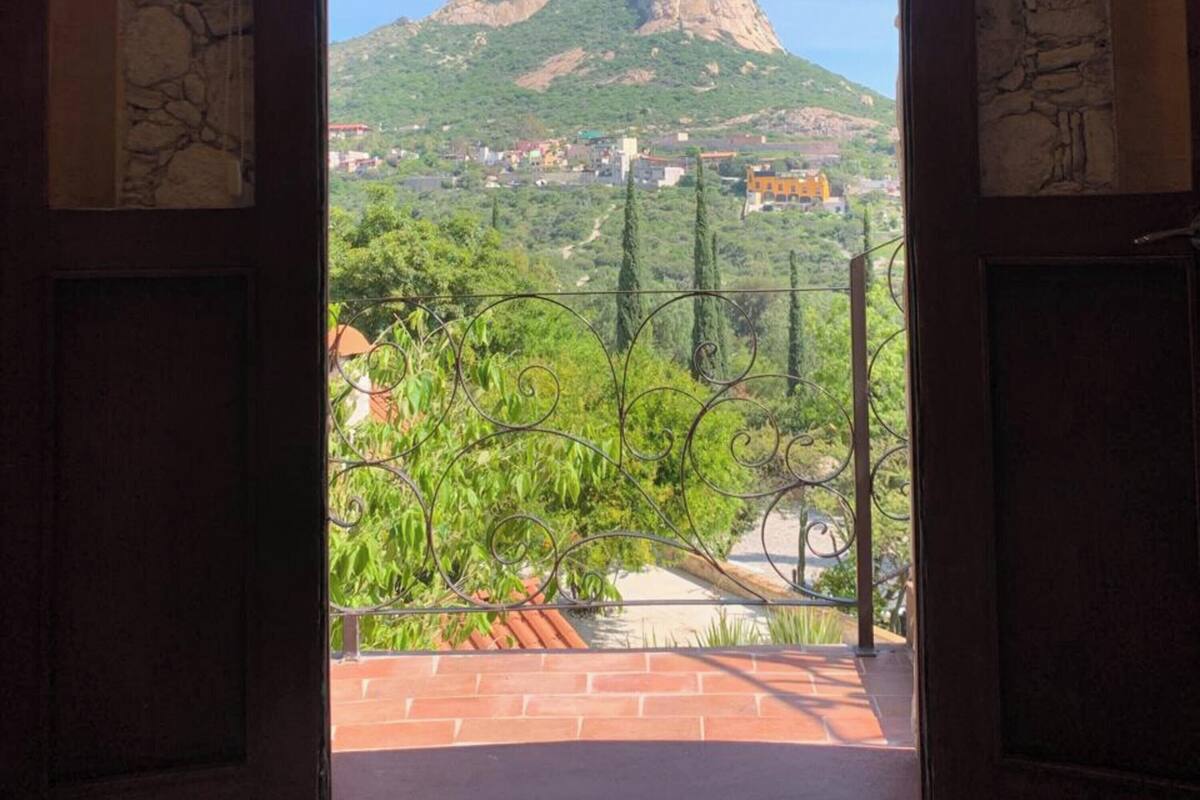 An open doorway with a view of a mountain and a town.
