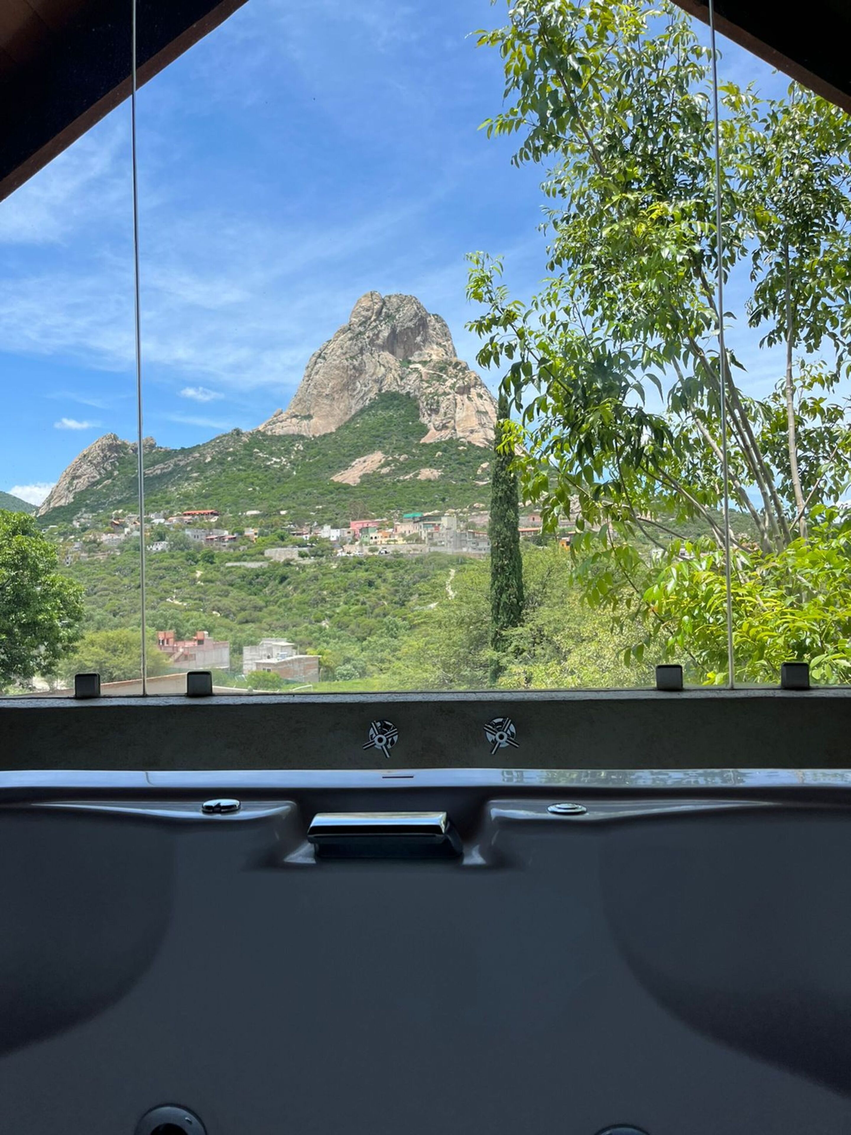 A car's interior with a view of a mountainous landscape and a village below.
