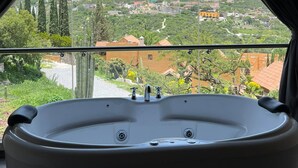 A bathroom with a bathtub, a view of a mountain, and a balcony with a railing. - Hotel Zidada and Chalets (Ezequiel Montes)