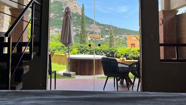 A room with a view of a mountain, a hot tub, and outdoor seating. - Hotel Zidada and Chalets (Ezequiel Montes)