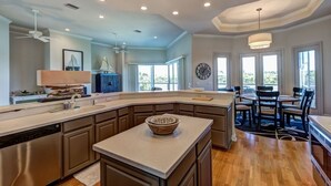 A spacious kitchen with a large island, built-in appliances, and ample natural light from large windows.