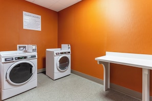 A laundry room with two washing machines and a table. - Holiday Inn Express & Suites Kearney by IHG (Kearney)