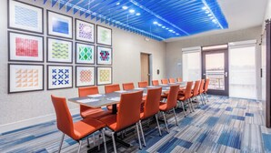 A conference room with a long table, orange chairs, and framed artwork on the walls. - Holiday Inn Express & Suites Kearney by IHG (Kearney)