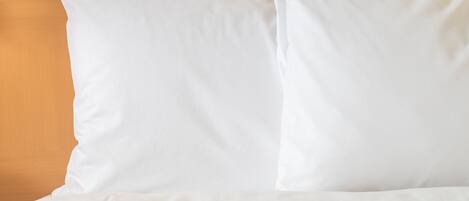 A bed with white bedding and a wooden headboard.