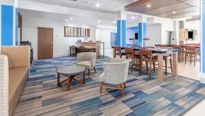 A modern hotel lobby with a mix of seating areas, a reception desk, and a dining area. - Holiday Inn Express & Suites Kearney by IHG (Kearney)