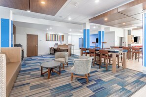 A modern hotel lobby with a mix of seating areas, a reception desk, and a dining area. - Holiday Inn Express & Suites Kearney by IHG (Kearney)
