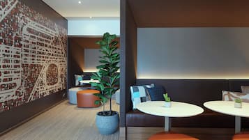A modern lounge area with seating, a coffee table, and a decorative plant.