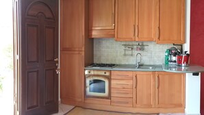 Eine Küche mit Holzausstattung, fest eingebautem Backofen, Spüle und Herd.