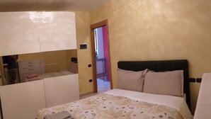 Ein Hotelzimmer mit Bett, einem Kleiderschrank und einem durchgegangenen Badezimmereingang.
