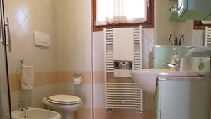 Ein Badezimmer mit Bidet, Toilette und Waschbecken.