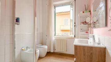 A modern bathroom with a bidet, toilet, and sink.