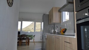 A modern kitchen with wooden cabinets, a stainless steel sink, and a bowl of fruit on the counter. - House overlooking the volcano with garden, solarium, terrace and barbecue (Ye)