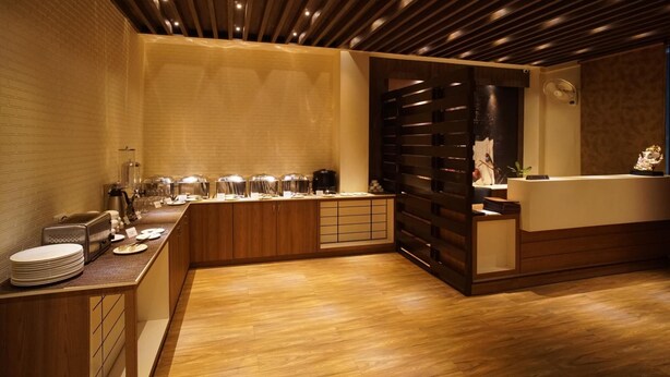 A modern kitchen with a wooden countertop, built-in appliances, and a wooden ceiling. - Hotel Shree Kanha Residency (Prayagraj)