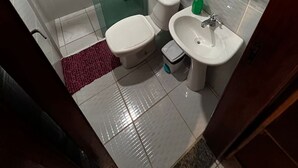 A bathroom with a glass-enclosed shower, a toilet, a sink, and a towel rack. - Mareou (Angra dos Reis)